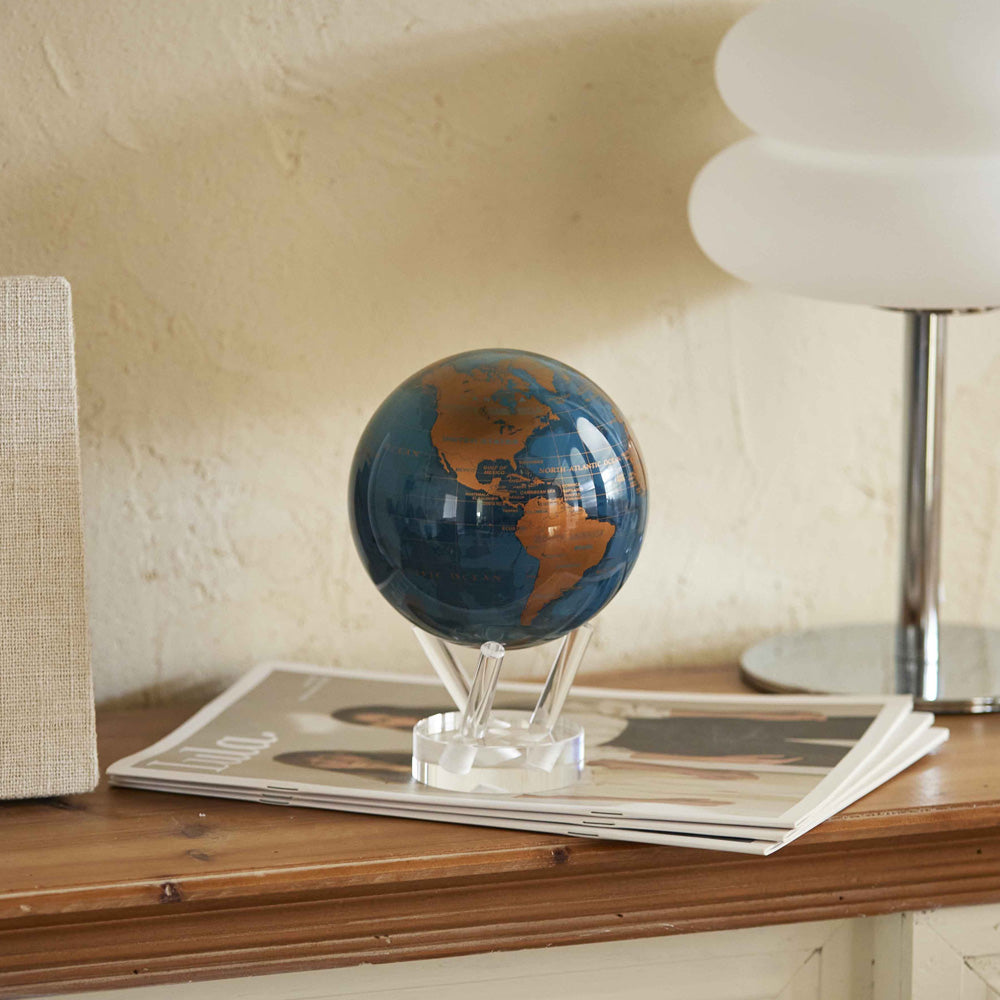 Blue and gold rotating globe decor displayed on wooden console table