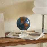 Blue and gold rotating globe decor displayed on wooden console table