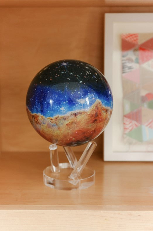 James Webb Carina Nebula Globe MOVA displayed on a shelf, space-inspired décor with NASA imagery.