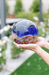 James Webb Carina Nebula MOVA Globe held outdoors, showcasing colorful cosmic nebula design in sunlight.