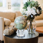 Antique Cassini Green MOVA Globe beside floral arrangement vintage decor