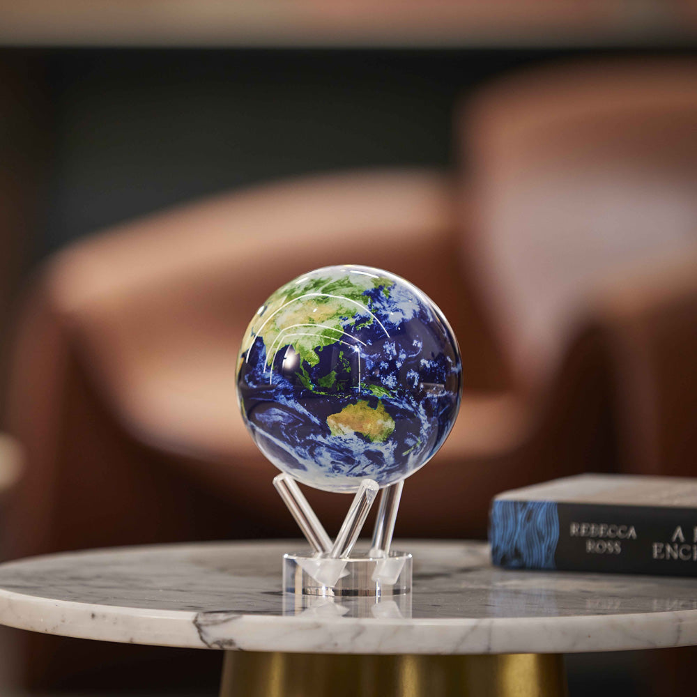 Earth with Clouds MOVA Globe on marble tabletop with books