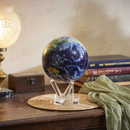 Earth with Clouds MOVA Globe displayed on wooden table beside books